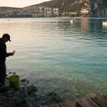Pêche lac de Sainte-Croix : pêcheur avec carte près de l’eau au bord du lac