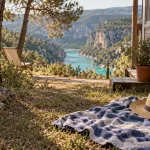 Camping naturiste gorges du verdon, serviette sur l’herbe près du mobil-home, eau turquoise au loin